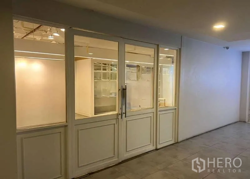 Retail Space for rent - Shopfront with double glass doors and windows viewed from an interior corridor.