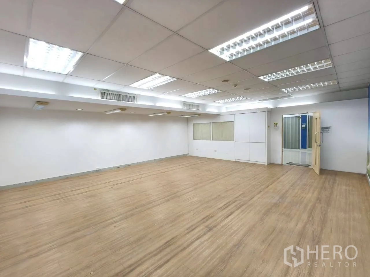 Office Space for rent in Chatuchak, Bangkok - Spacious open-plan office with wood-look flooring, drop ceiling and fluorescent lighting.