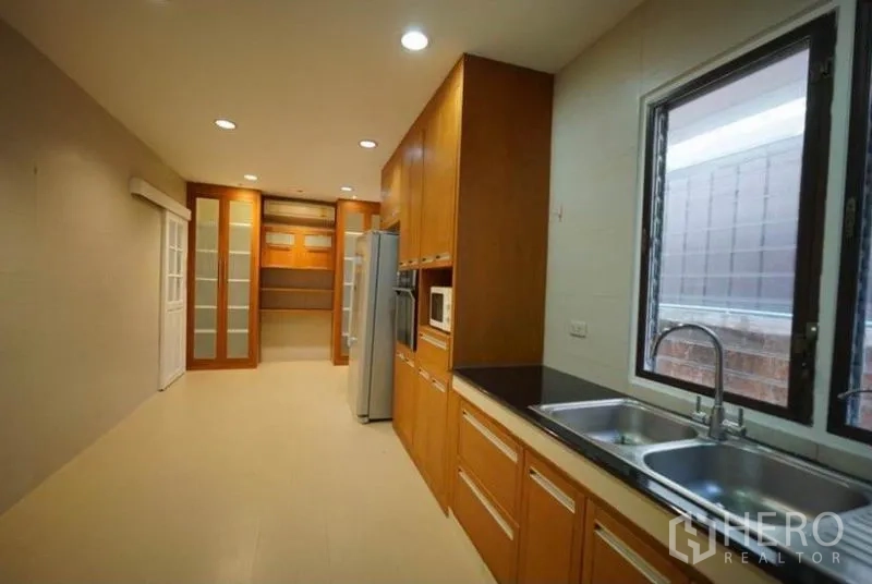 Detached House for rent in Bang Phli, Samut Prakan - Second kitchen view showing double sink, pantry storage and large window.