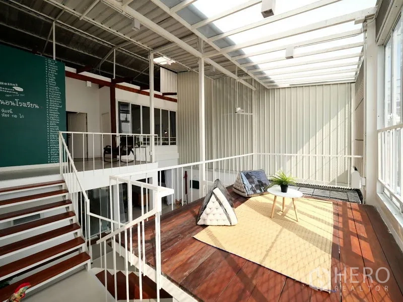 Townhouse for rent in Khlong Toei, Bangkok - Sunroom mezzanine with glass roof, wooden deck and lounge cushions in a Bangkok townhouse.