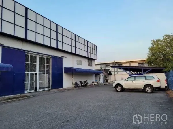 Warehouse for rent in Phra Khanong, Bangkok - Warehouse exterior with wide driveway, blue facade and on-site parking