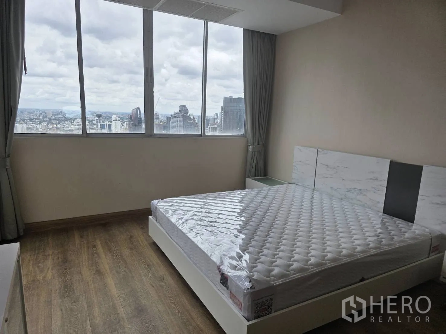 Condominium for rent in Khlong Toei, Bangkok - King bedroom with marble headboard and picture windows over the city.