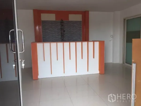 Factory for rent in Lam Luk Ka, Pathum Thani - Ground-floor reception area with tiled floor and an orange-and-white counter behind glass doors.