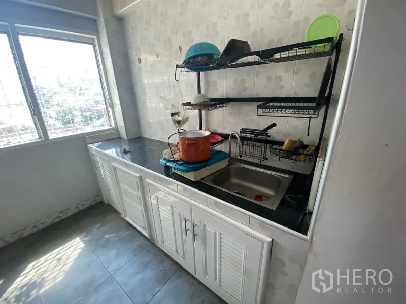 店屋 出租或出售在Suan Luang, Bangkok - 采光良好的小厨房，设窗户、水槽、台面与置物架。