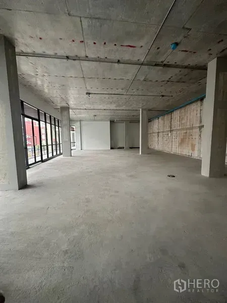 Retail Space for rent in Bang Na, Bangkok - Open-plan retail shell with floor-to-ceiling glass frontage, concrete ceiling and columns in Bang Na.