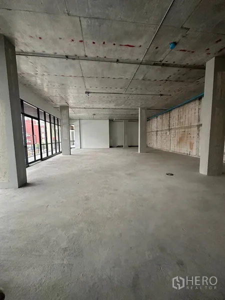 Retail Space for rent in Bang Na, Bangkok - Open-plan retail shell with floor-to-ceiling glass frontage, concrete ceiling and columns in Bang Na.