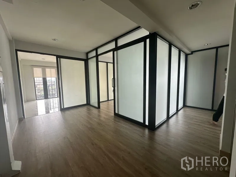 Home Office for rent in Suan Luang, Bangkok - Office zone with multiple glass-partitioned rooms leading to balcony doors.