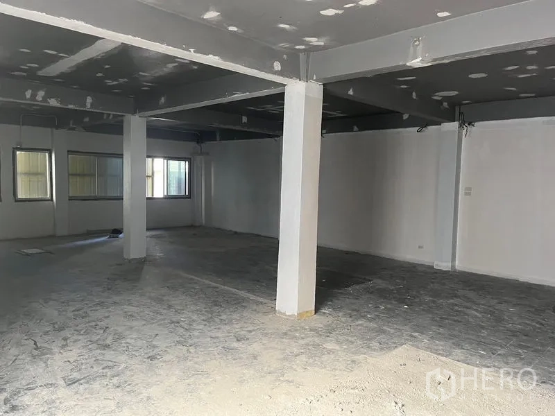 Retail Space for rent in Pathum Wan, Bangkok - Spacious retail area with windows on two sides and concrete flooring.