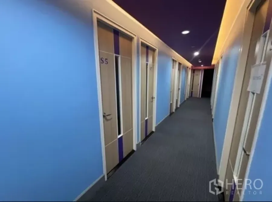 Retail Space for rent in Bang Rak, Bangkok - Bright corridor with blue walls and numbered doors leading to private rooms in a retail unit.