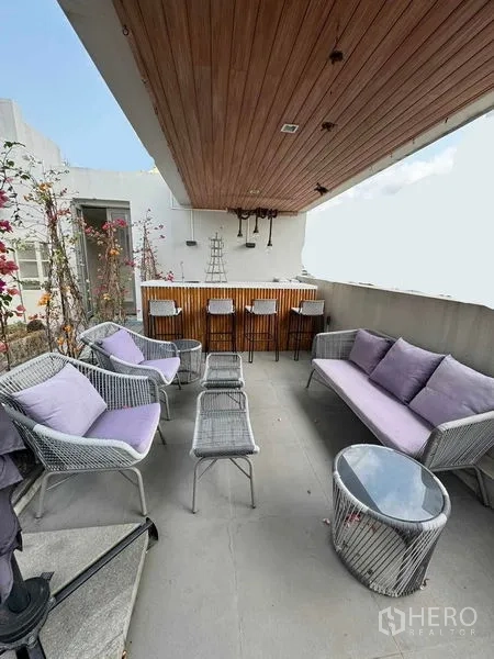 Townhouse for rent in Watthana, Bangkok - Covered rooftop bar with stools and outdoor lounge seating.