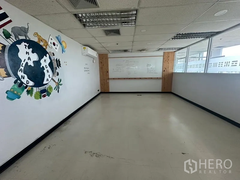 Office Space for rent - Training room perspective showing half-height glass partition, whiteboard and ceiling air vents.