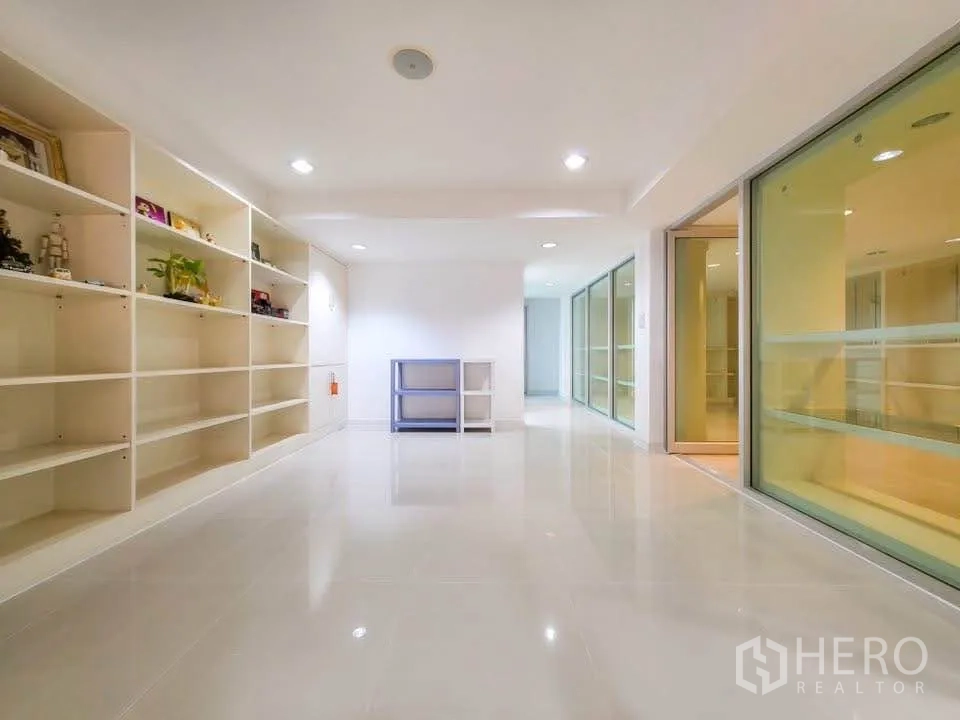 Office Space for rent in Khlong Toei, Bangkok - Spacious open-plan office zone with wall shelving and large glass partitions.
