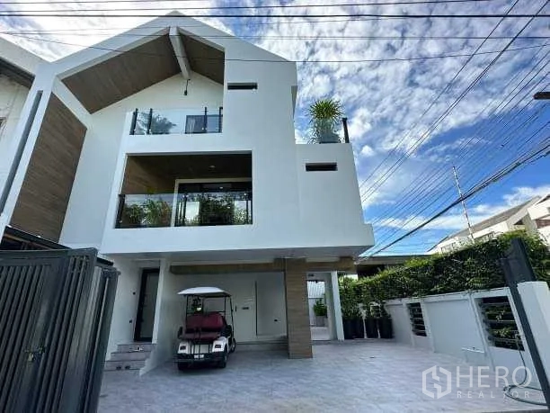 独立式住宅 出租在Suan Luang, Bangkok - 现代三层独栋外立面，带阳台与车道。