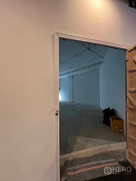 零售空间 出租 - 入口门通向空旷店面，均匀天花灯光，适合设置招牌。