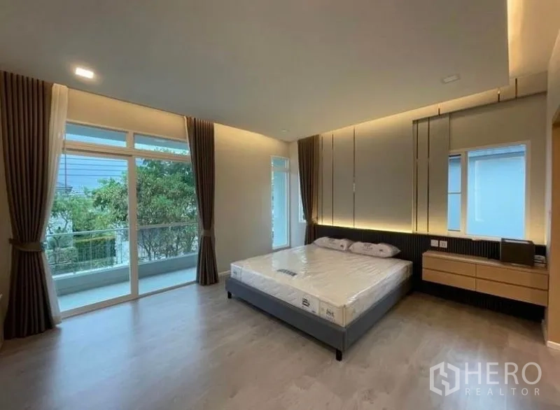 Detached House for rent in Prawet, Bangkok - Spacious master bedroom with floor-to-ceiling windows and access to a private balcony.