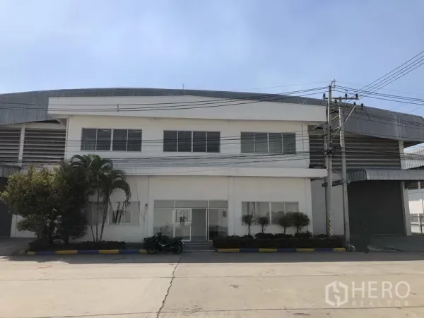 Warehouse for rent in Phra Nakhon Si Ayutthaya - Front view of a two‑storey office attached to a large warehouse in a secured industrial compound.