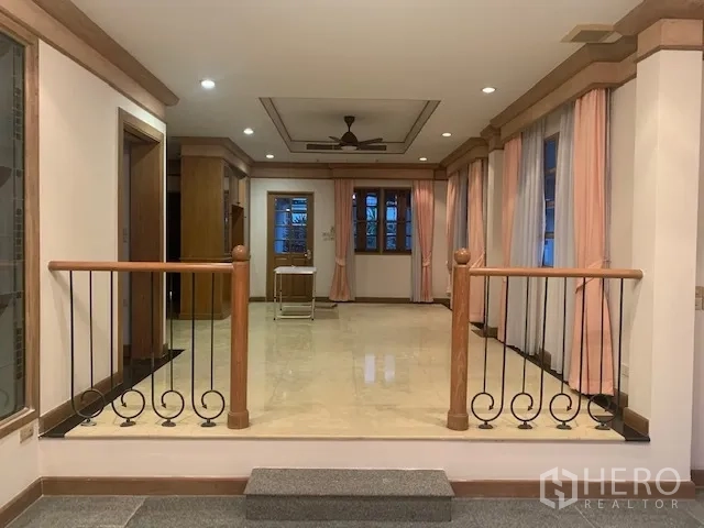 Detached House for rent in Khan Na Yao, Bangkok - Elevated entry foyer with polished tile floor, wrought-iron railings, ceiling fan, and curtained windows.