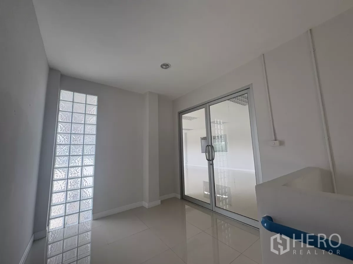 Factory for rent in Bang Phli, Samut Prakan - Landing area with glass-block wall and glass doors to office.