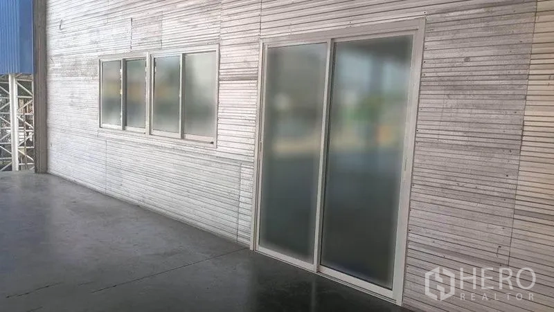 Warehouse for rent in Bang Phli, Samut Prakan - Exterior wall showing frosted sliding door and windows along the warehouse platform.