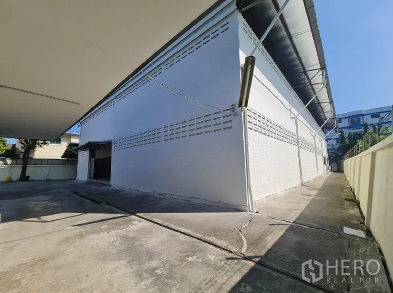 货栈 出租在Khlong Toei, Bangkok - 仓库侧步道，通风砖墙与屋檐