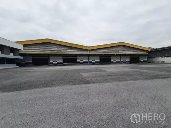 Factory for rent in Mueang Samut Prakan, Samut Prakan - Warehouse frontage with covered loading bays and easy truck access.