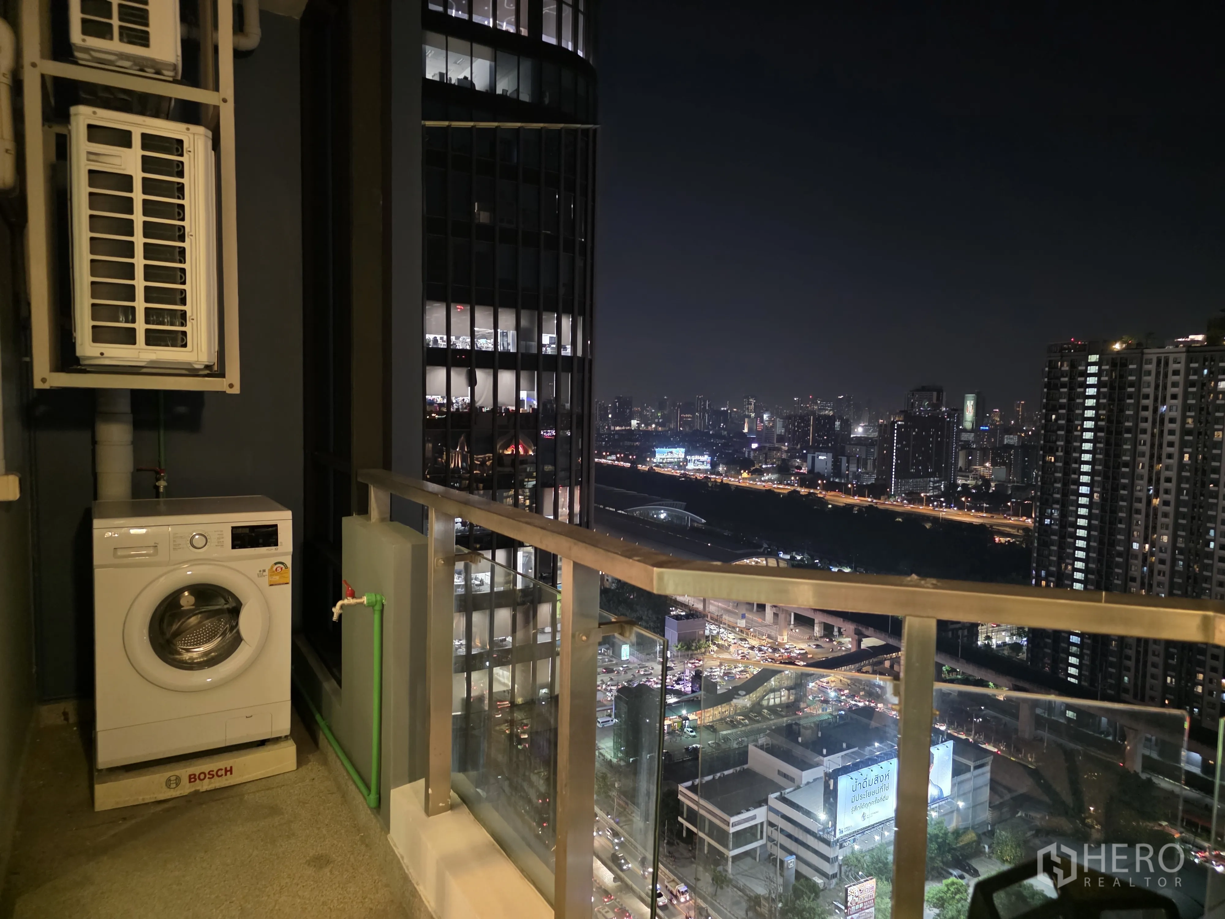 Condominium for rent in Bang Kapi, Bangkok - Balcony service area with washing machine and expansive night city view.