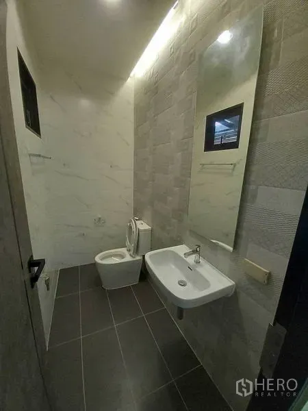Retail Space for rent in Khlong Toei, Bangkok - Modern restroom with wall tiles, toilet and a sink with mirror.