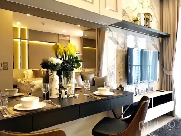 Condominium for rent in Watthana, Bangkok - Bright living and dining area with marble TV wall, floating dining counter, and a view into the cozy bedroom.