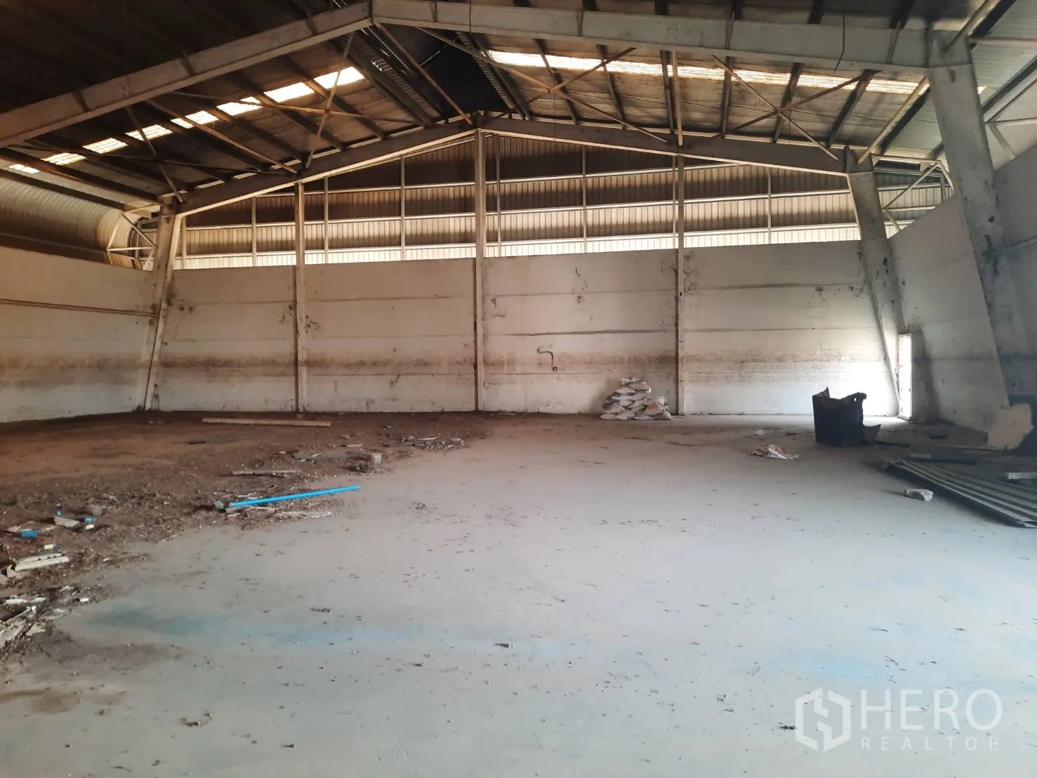 Factory for sale in Bang Pa-in, Phra Nakhon Si Ayutthaya - Empty production area with metal beams and ventilation panels along the roof.