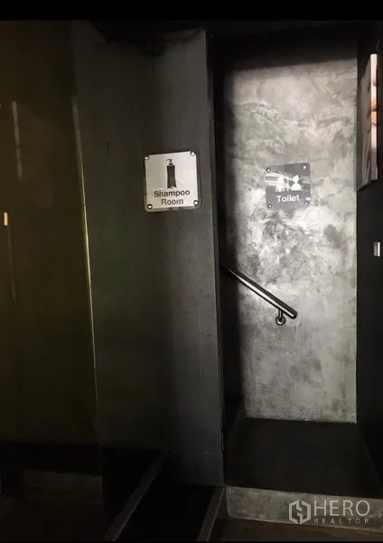 Office Space for rent in Pathum Wan, Bangkok - Internal stairwell with signage leading to the toilet on a concrete wall.