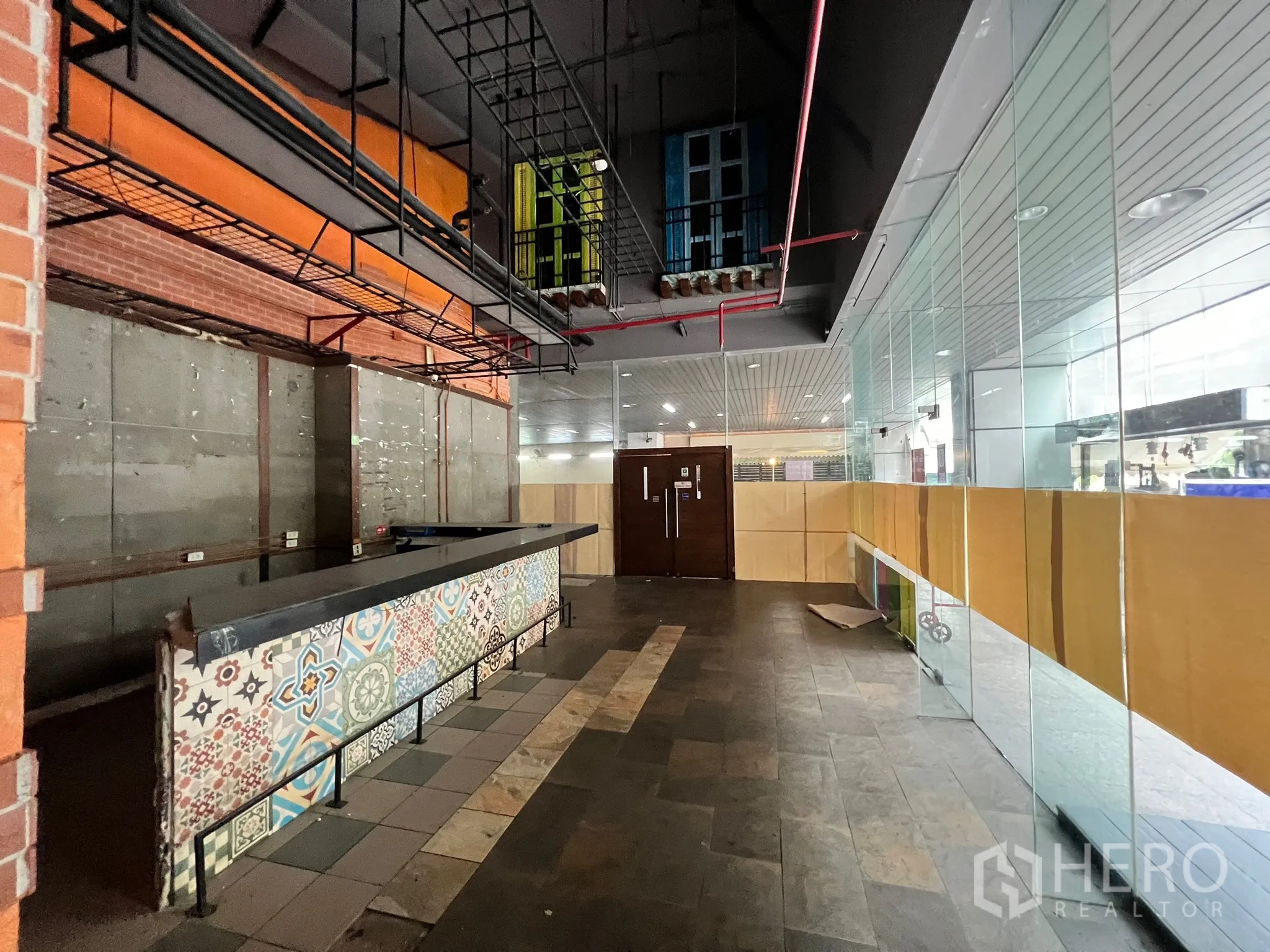 Retail Space for rent in Watthana, Bangkok - Long patterned service counter facing full-height glass shopfront and corridor.