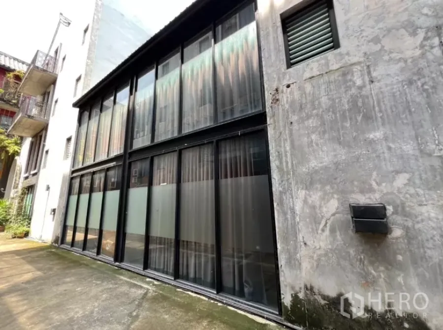 Home Office for rent in Pathum Wan, Bangkok - Four-storey home office exterior with tall black-framed glass facade.