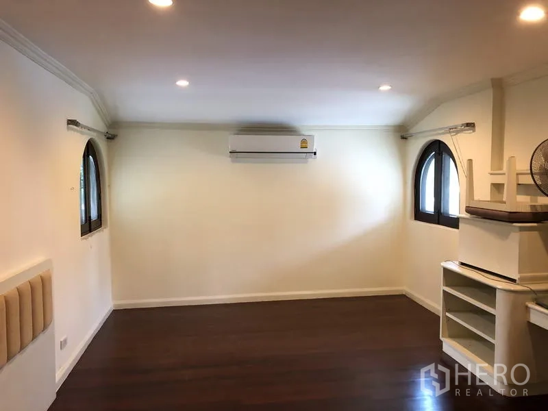 Detached House for rent in Khan Na Yao, Bangkok - Cozy bedroom with arched windows, air-conditioning and recessed lighting.
