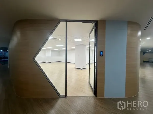 Office Space for rent in Chatuchak, Bangkok - Modern office entrance with geometric glass door set in a curved wood-clad wall.