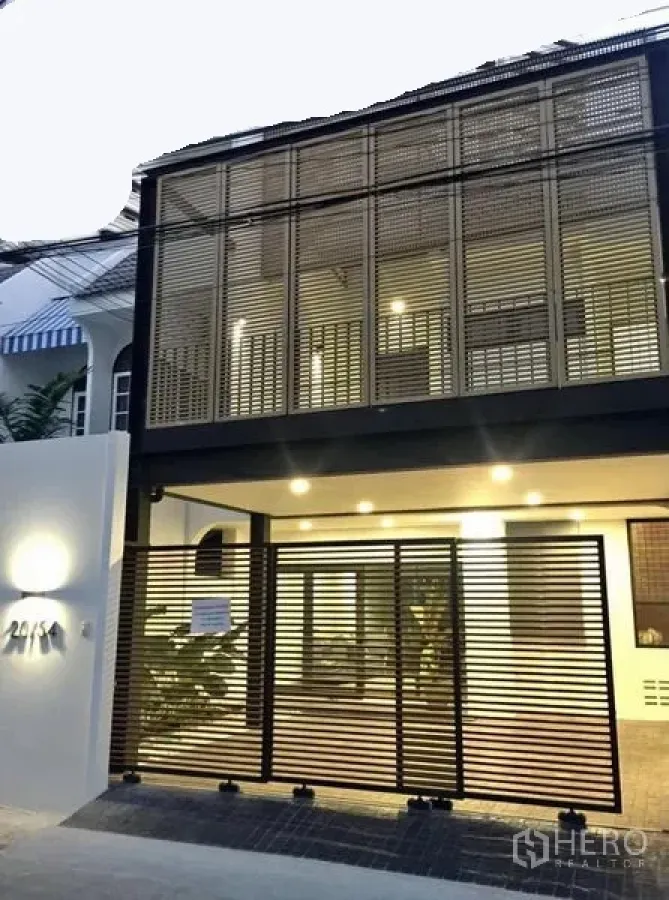 ทาวน์เฮาส์ ให้เช่าในKhlong Toei, Bangkok - ด้านหน้าทาวน์เฮ้าส์สองชั้นสไตล์โมเดิร์น มีระแนงบังสายตาและโรงรถมีหลังคาพร้อมไฟสว่าง