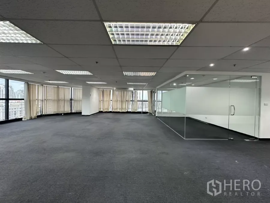 Office Space for rent in Watthana, Bangkok - Wide office area featuring wraparound windows with blinds and a long glass partition.