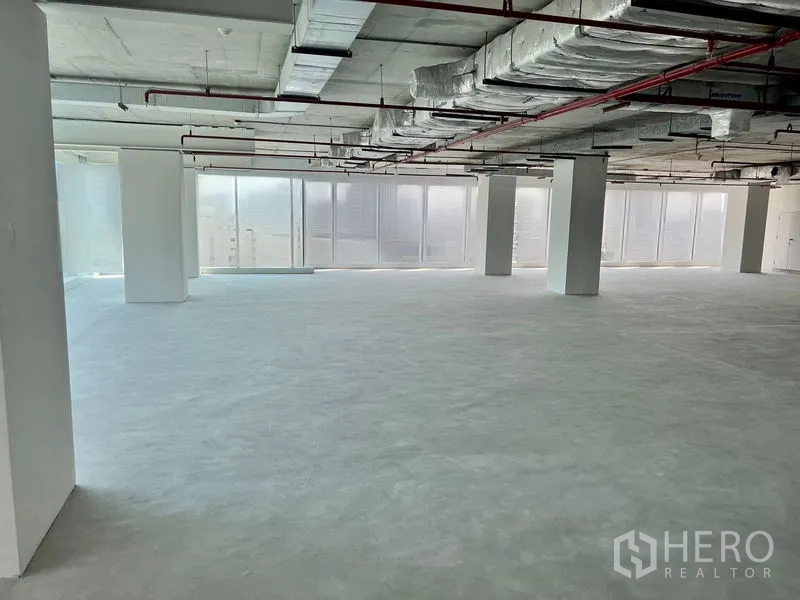 Office Space for rent in Sathon, Bangkok - Bright unfinished office floor showing floor-to-ceiling glazing, concrete floor and multiple structural columns ready for fit-out.