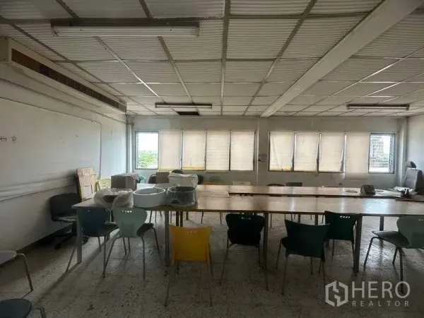 Factory for rent in Sai Noi, Nonthaburi - Simple meeting room with long tables, mixed chairs and windows with blinds along one wall.
