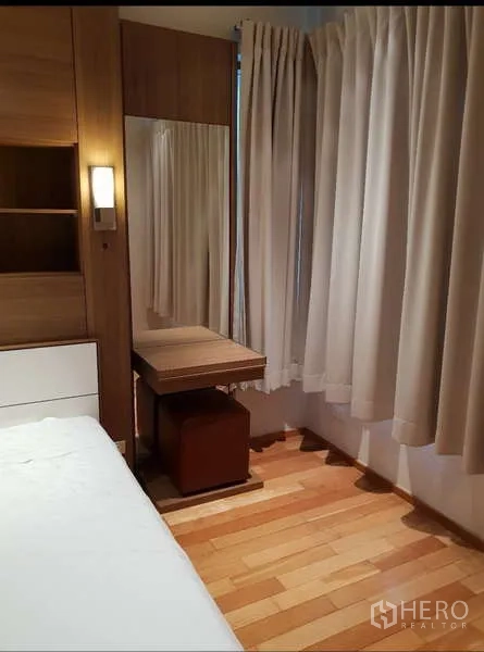 Condominium for rent - Bedroom corner featuring a dressing table, large mirror, ottoman and full-length curtains.