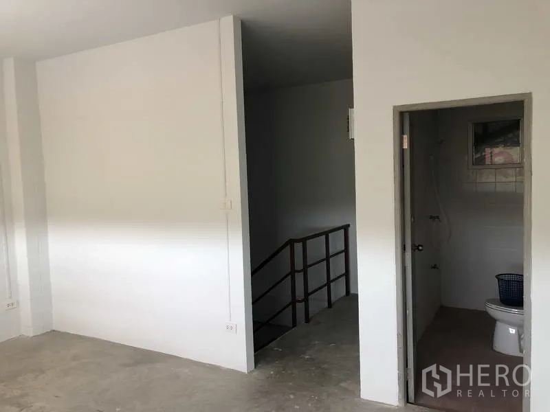 联排别墅 出售在Bang Bua Thong, Nonthaburi - 楼梯平台，带通往瓷砖浴室的门。