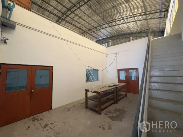 Warehouse for rent in Bang Phli, Samut Prakan - Stairwell and double doors connecting to upper warehouse level with metal roof.