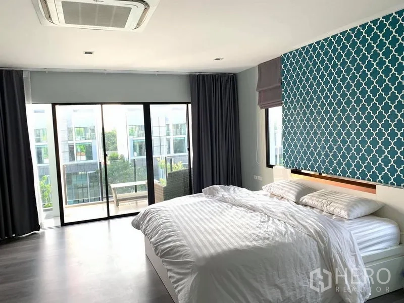 Home Office for rent - Spacious bedroom with teal feature wall, king bed and sliding doors opening to a balcony.