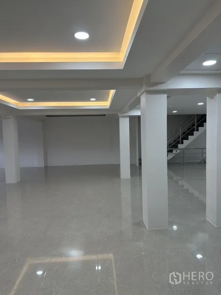 Office Space for rent or sale in Huai Khwang, Bangkok - Open office with drop ceiling, warm cove lights and glossy tiles.