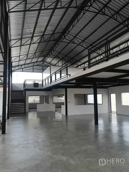 工厂 出租或出售在Mueang Samut Prakan, Samut Prakan - 开敞式仓库空间，带夹层办公室、楼梯与钢桁架屋顶。