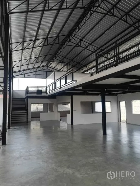 工厂 出租或出售在Mueang Samut Prakan, Samut Prakan - 开敞式仓库空间，带夹层办公室、楼梯与钢桁架屋顶。