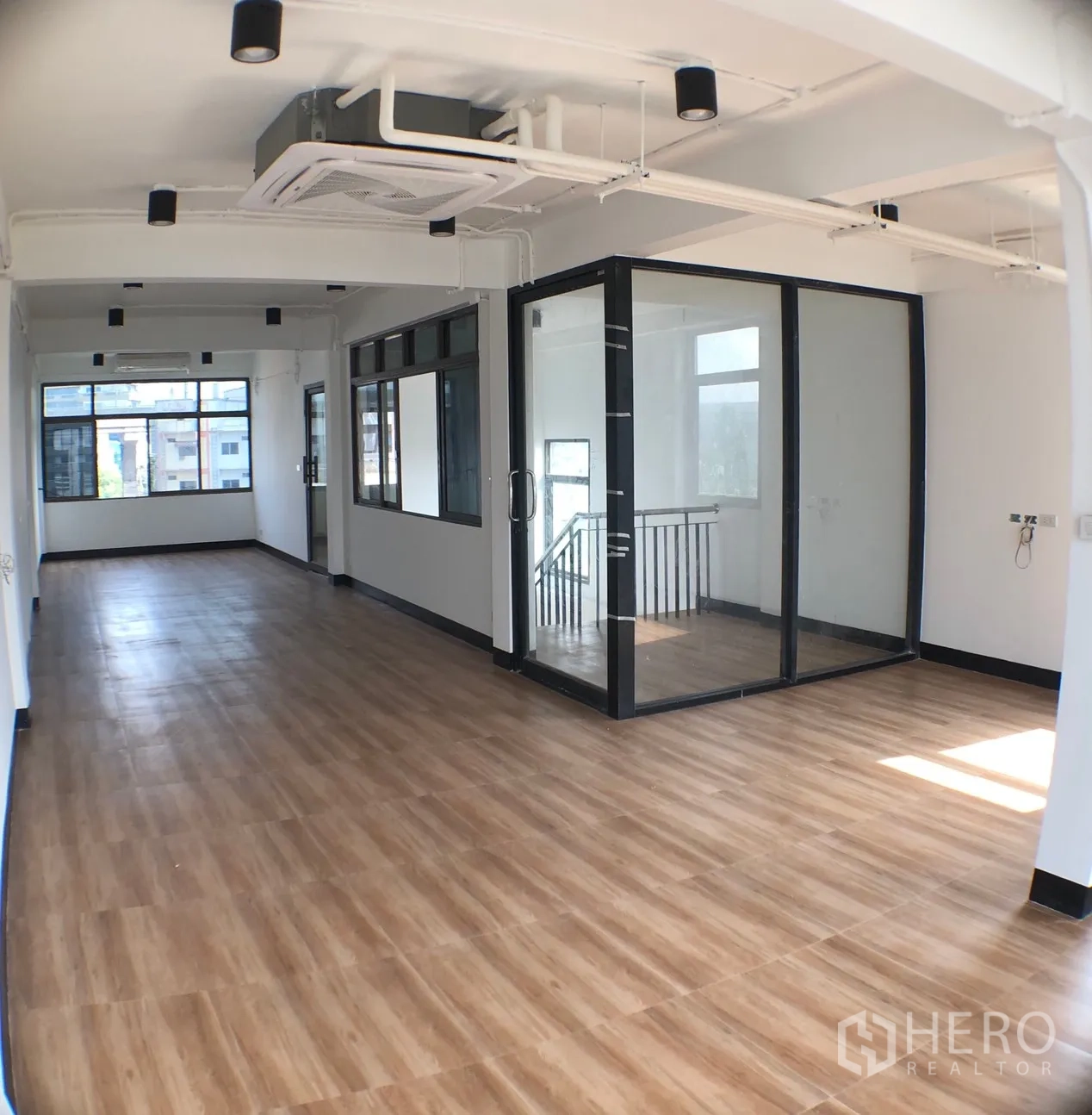 Home Office for rent in Phra Khanong, Bangkok - Open office level with a glass-walled room beside the staircase and ceiling spotlights.