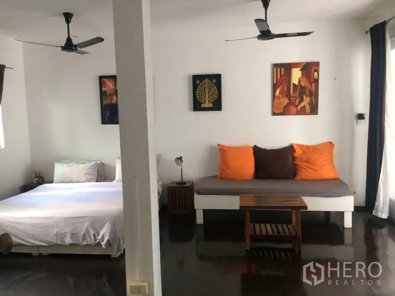 独立式住宅 出租在Sathon, Bangkok - 宽敞起居/睡眠区，配床、日间床、吊扇与墙面装饰画。