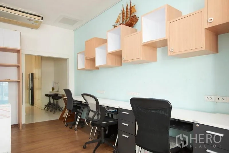 Home Office for rent in Wang Thonglang, Bangkok - Open-plan workspace with long desks, task chairs and wall-mounted cube shelves.