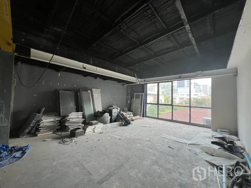 Retail Space for rent in Watthana, Bangkok - Upper room with floor-to-ceiling window offering city views, unfinished flooring.