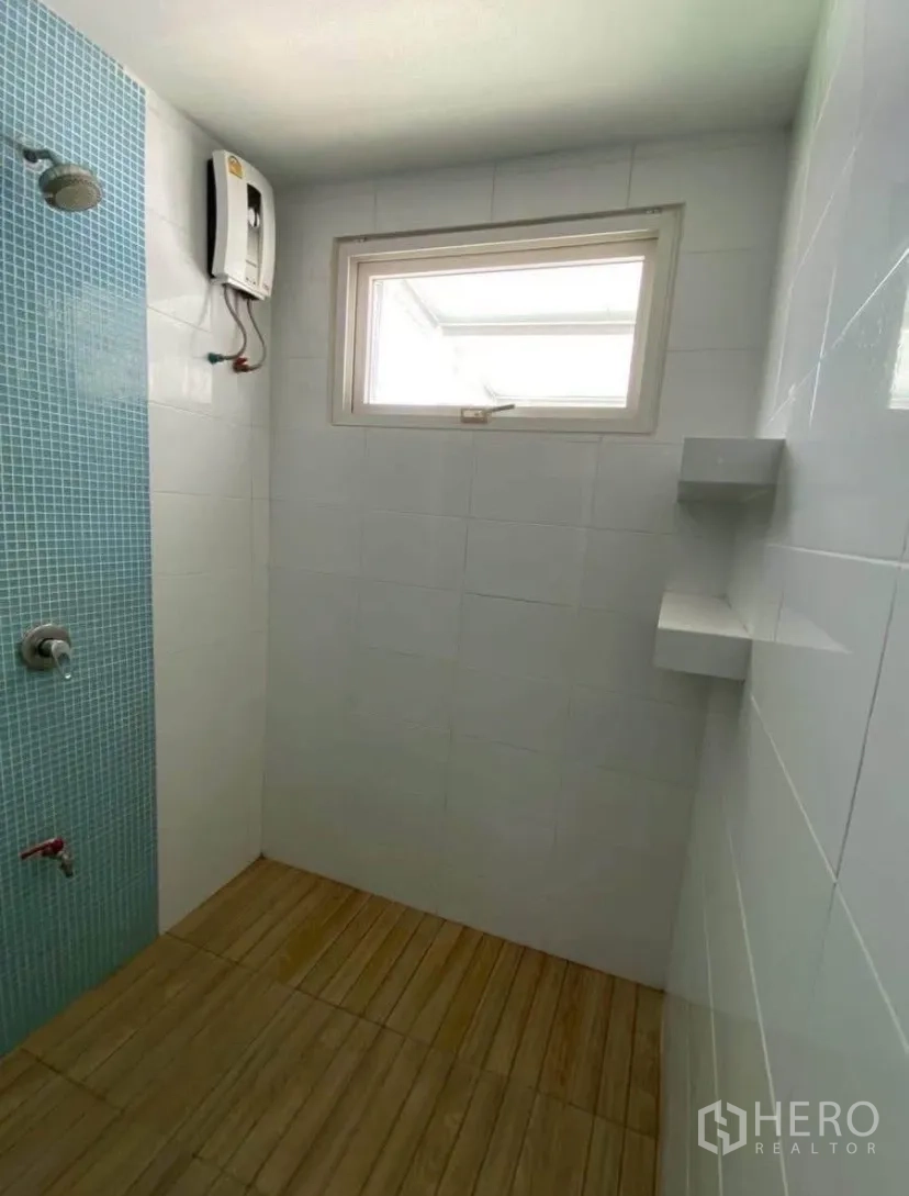 Townhouse for rent in Phra Khanong, Bangkok - Shower room with blue mosaic accent wall, water heater, and wood-look floor.